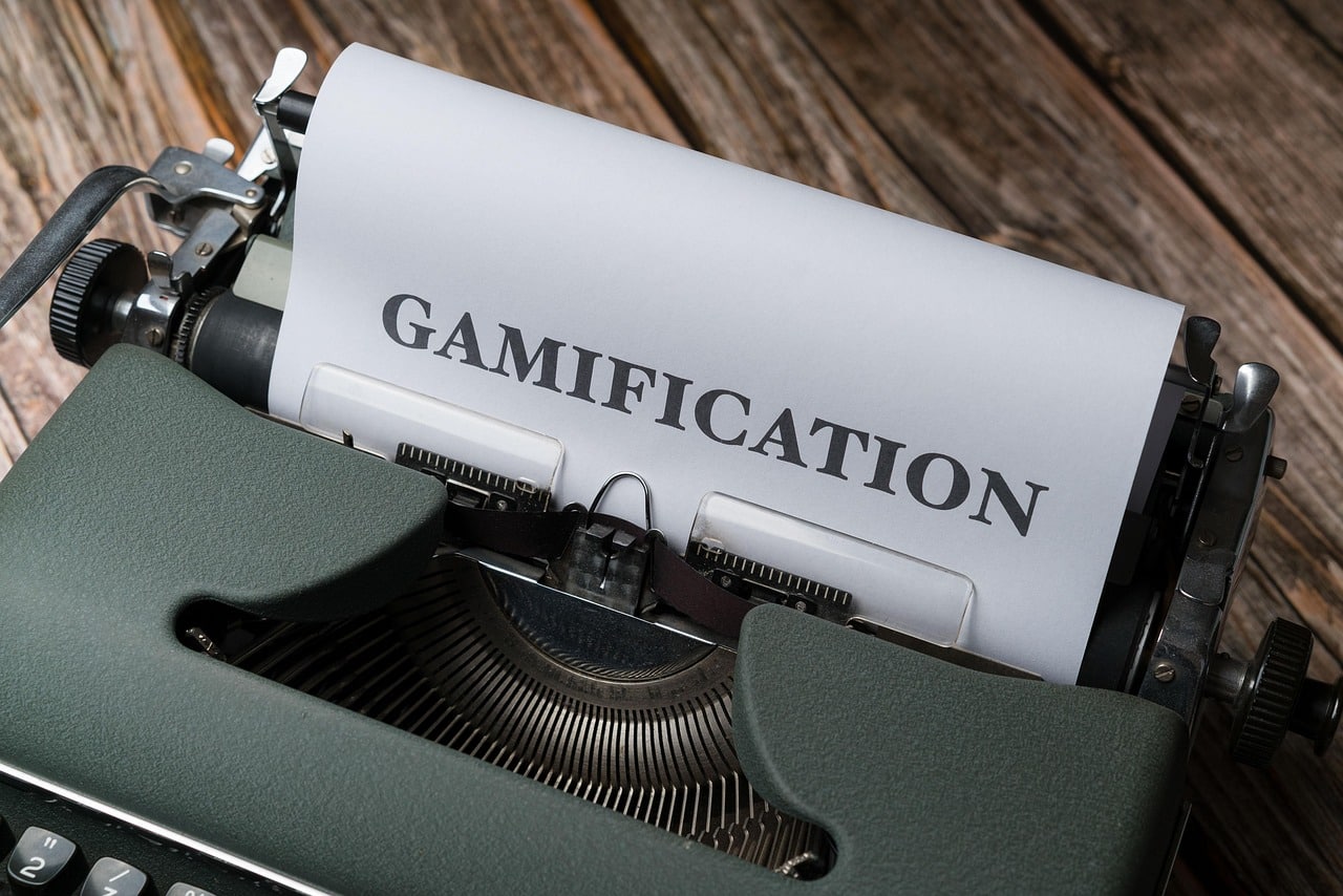 Macchina da scrivere vintage con foglio che riporta la parola "Gamification" – concetto di gamification applicata al lavoro e ai call center.